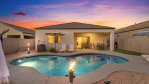 A backyard with a swimming pool, a covered patio, and a fire feature. - East Valley Peaceful Oasis w/PRIVATE Pool that is HEATED at no extra cost (Florence)
