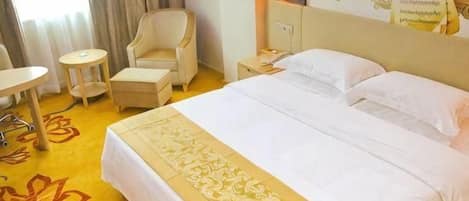Una habitación de hotel con una cama, un escritorio, una silla y una mesita.