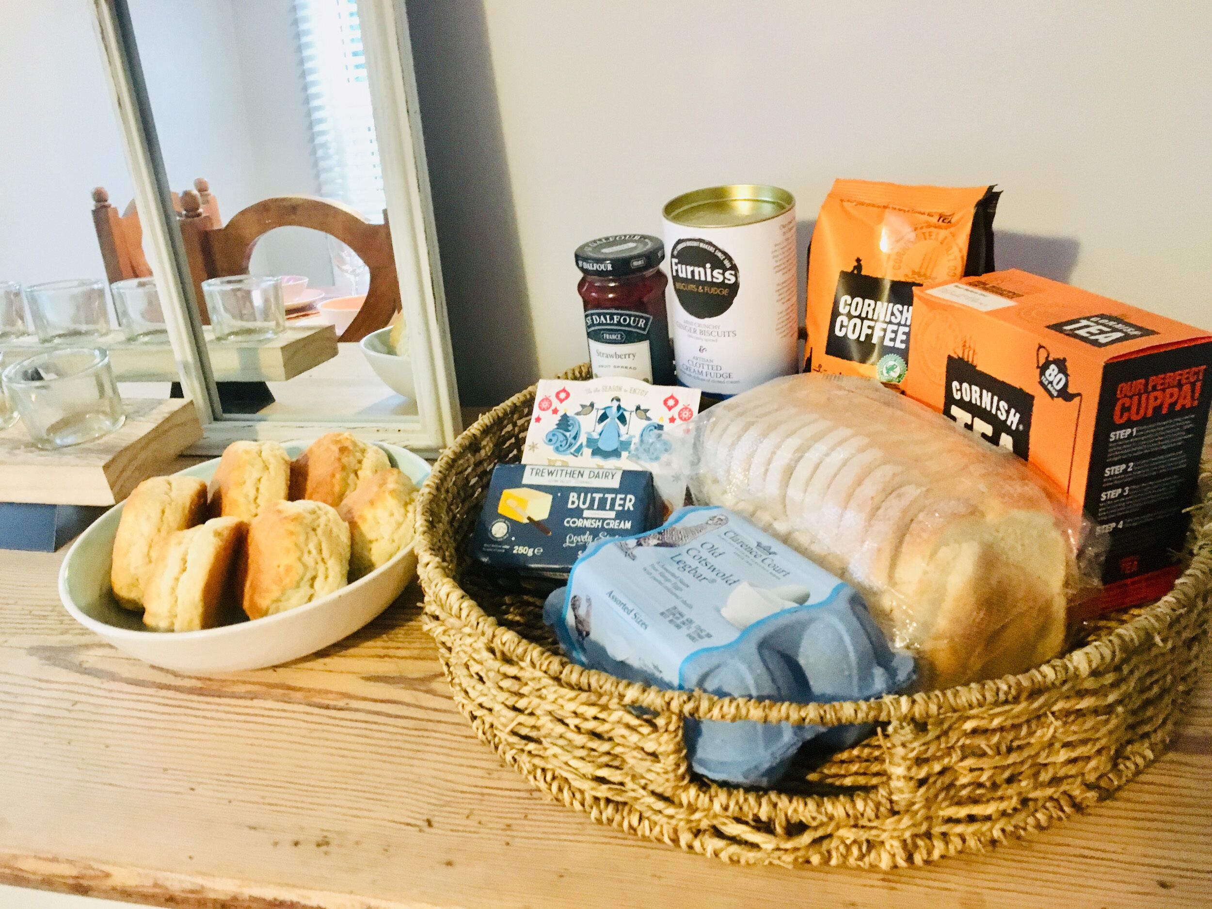 A breakfast setting with bread, biscuits, jam, and coffee products.