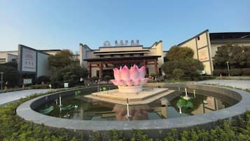 A building with a lotus pond in front.