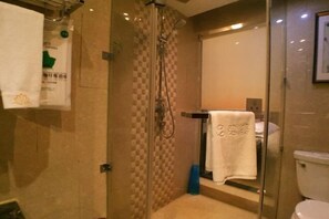 A bathroom with a glass-enclosed shower, a toilet, and a towel rack. - Lianhua Hotel (Xiangcheng)