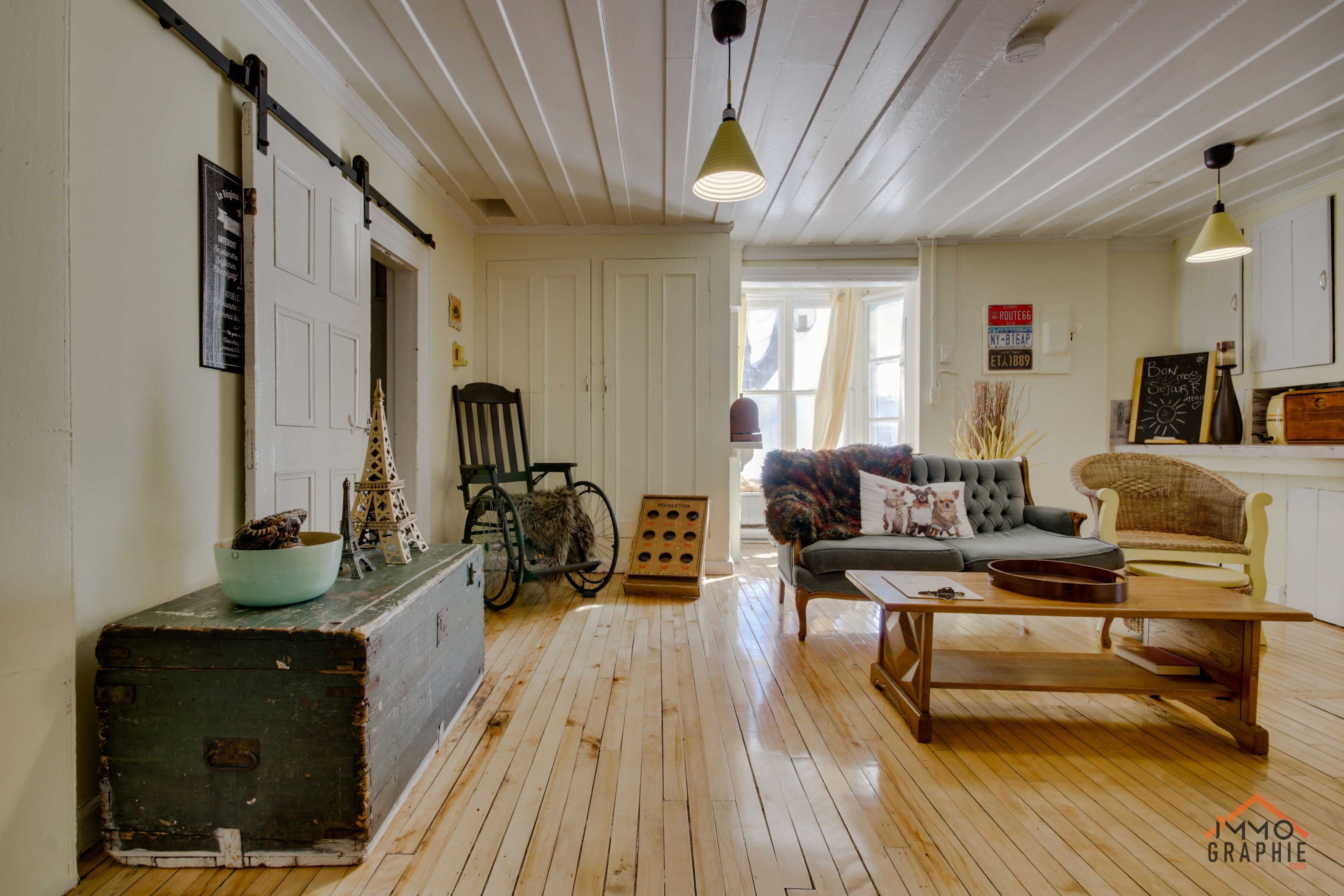 Un salon confortable avec un plancher en bois, un canapé, une table basse et un fauteuil roulant.