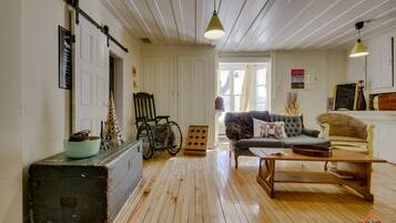 Un salon confortable avec un plancher en bois, un canapé, une table basse et un fauteuil roulant.