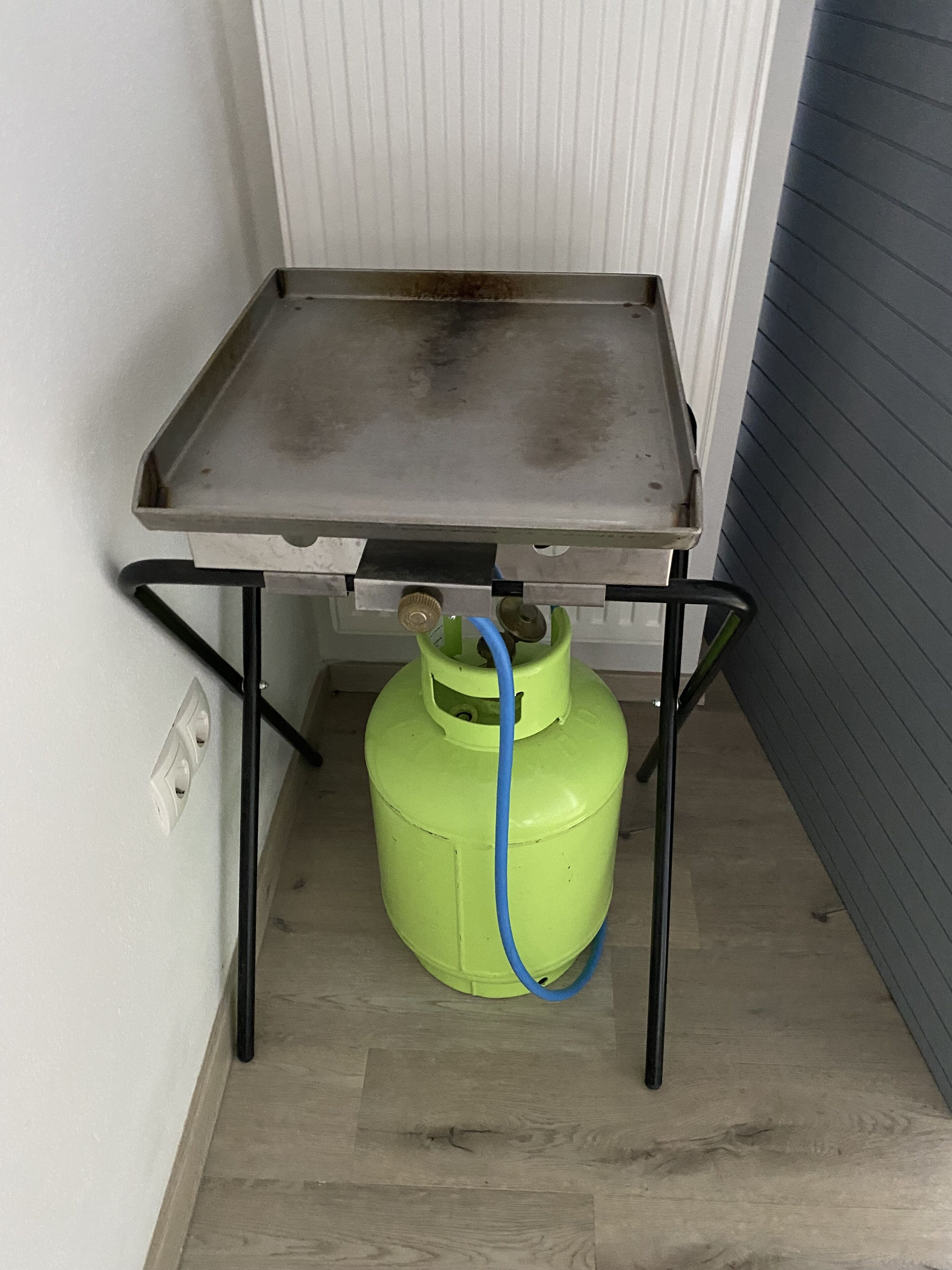 A small metal table with a gas cylinder underneath.