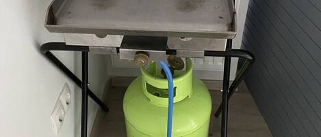 A small metal table with a gas cylinder underneath.