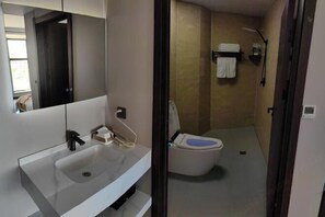 A bathroom with a sink, toilet, and shower. - Erenhot Hualian International Hotel (Erenhot)
