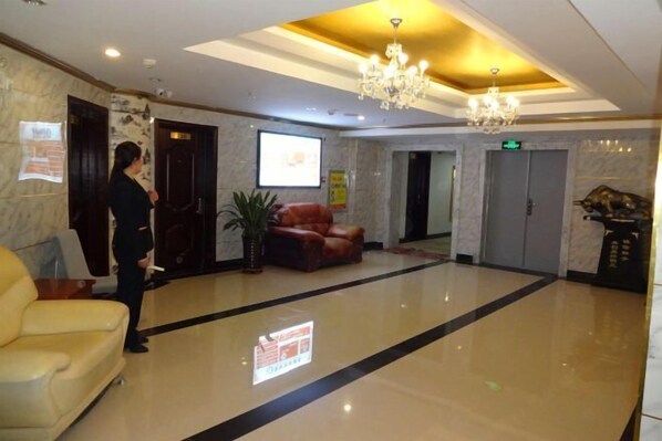 A hotel lobby with a marble floor, a chandelier, a sofa, and a potted plant. - Erenhot Hualian International Hotel (Erenhot)