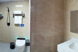 A modern bathroom with a toilet, a sink, and a towel rack. - Erenhot Hualian International Hotel (Erenhot)