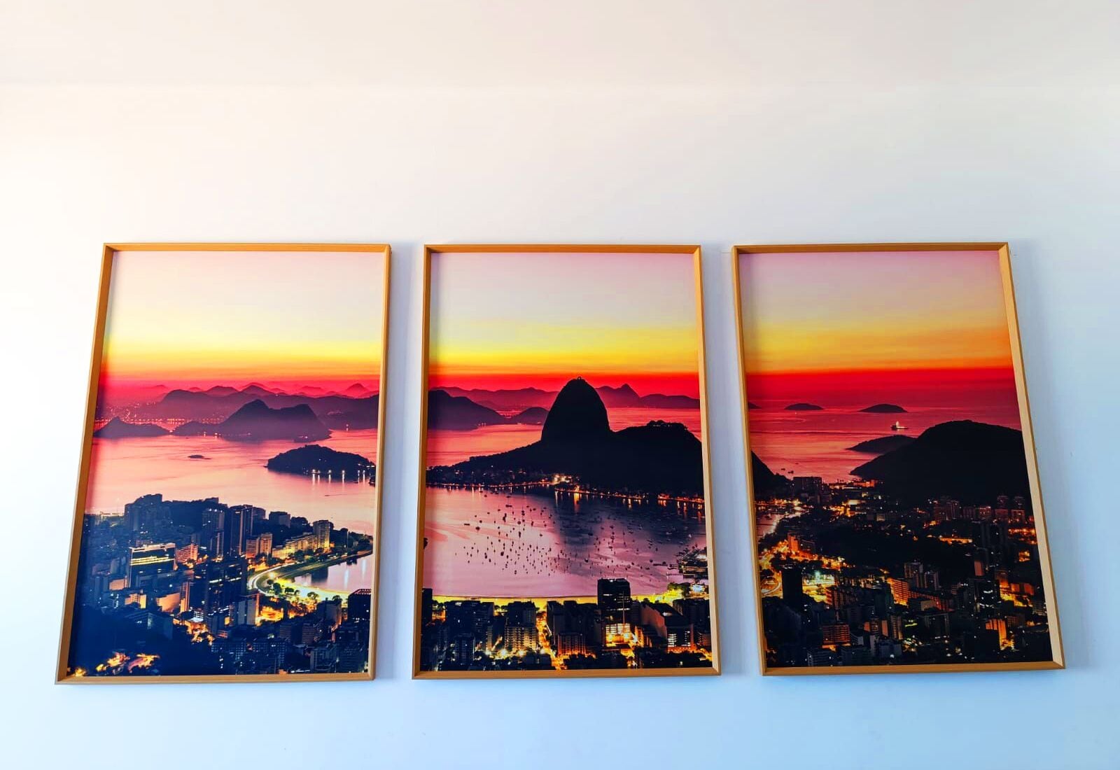 Três fotografias emolduradas de paisagens urbanas.