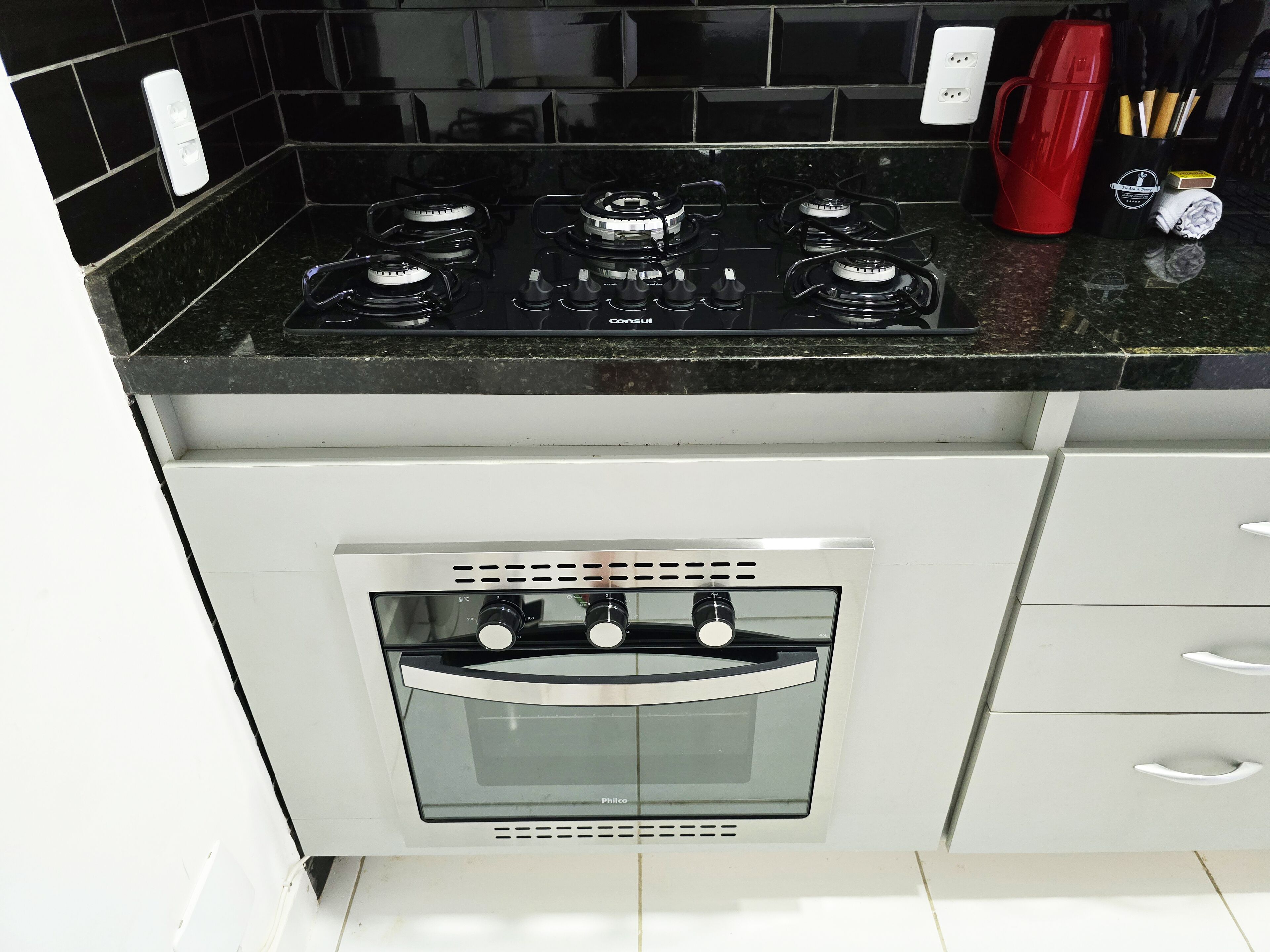 A kitchen with a gas stove, oven, and a coffee maker on the counter.