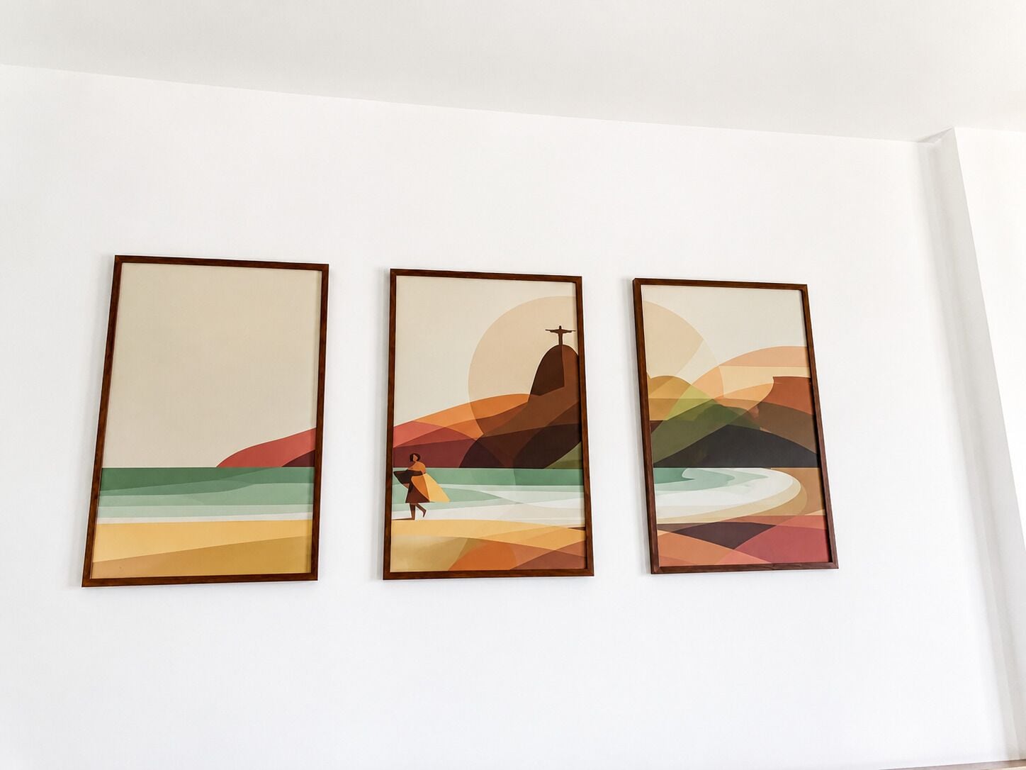 Three framed artworks on a wall.