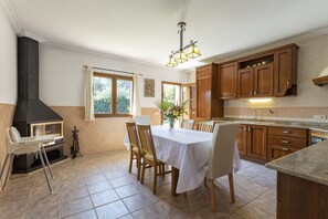A spacious kitchen with wooden cabinets, a dining table, and a built-in stove. - Quiet villa with 4 bedrooms, 2 bathrooms, barbecue, wifi and pool (Inca)