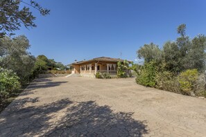 A house with a tiled roof, a porch, and a paved driveway surrounded by trees. - Quiet villa with 4 bedrooms, 2 bathrooms, barbecue, wifi and pool (Inca)