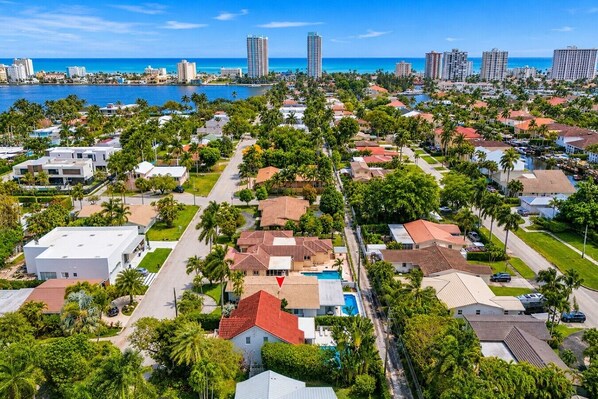A residential area with houses, palm trees, and a marina.