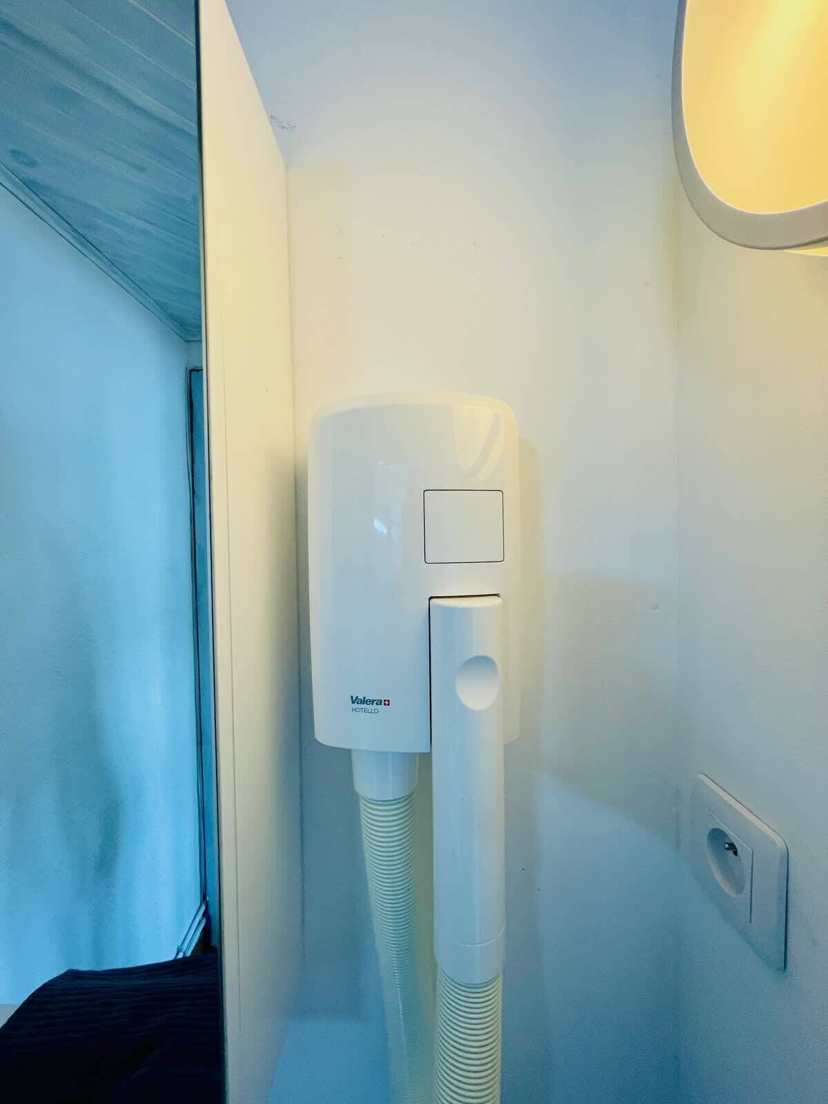 Hotelkamer in Valera met een witte airconditioner aan de muur, een raam met uitzicht en een deur.