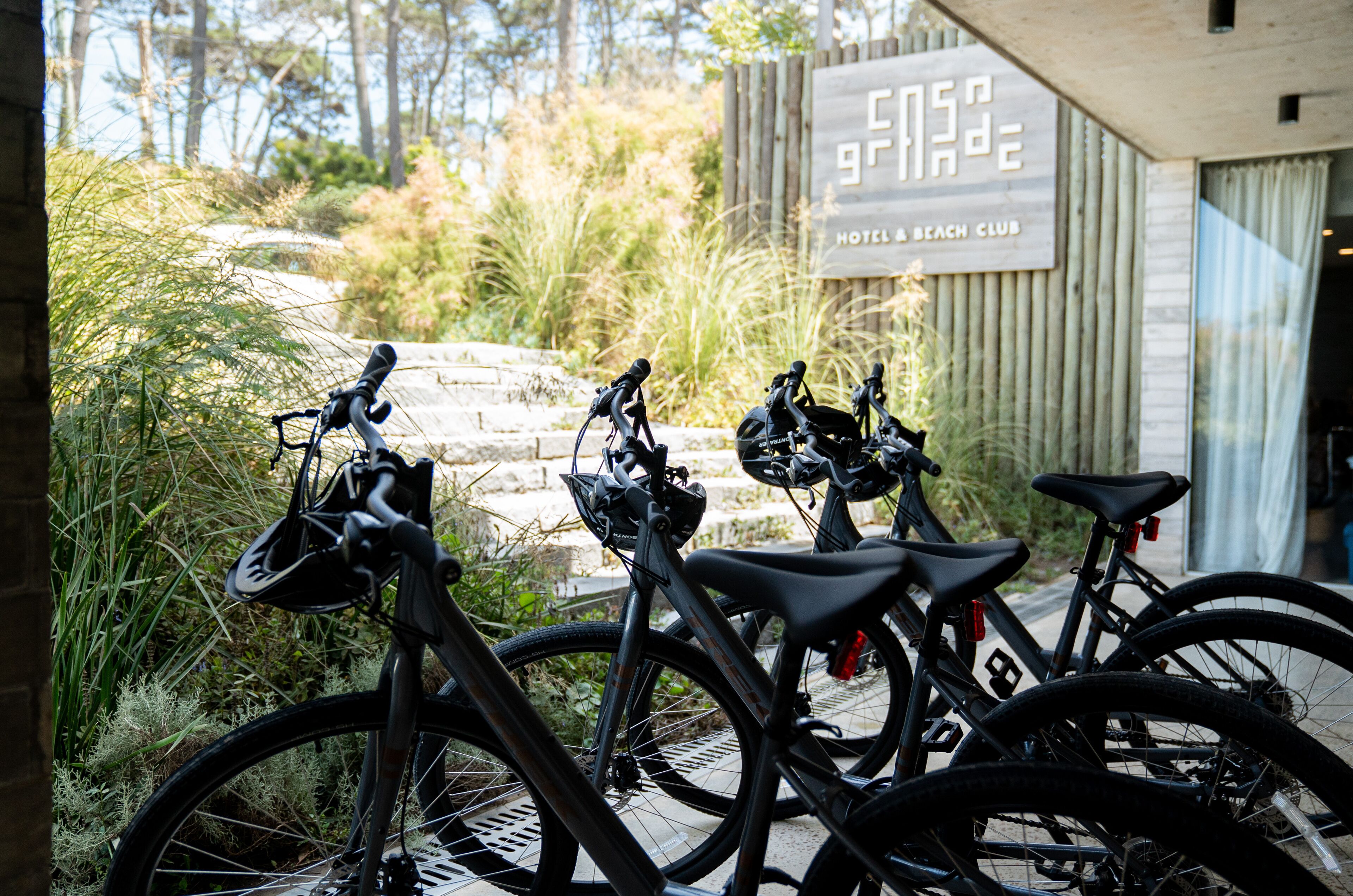 Three bicycles parked in front of a building labeled "Hotel Beach Club."