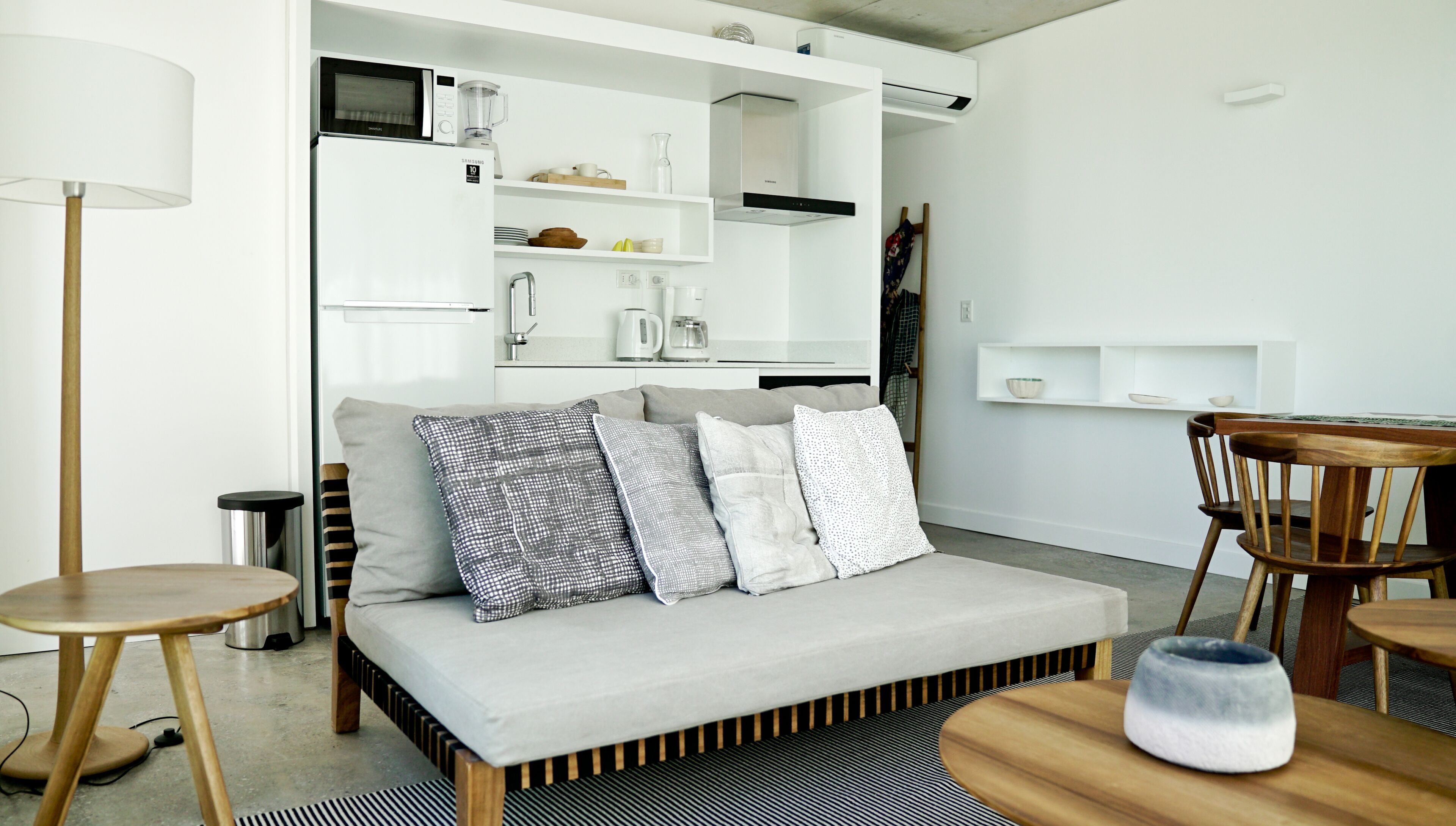 A modern living room with a sofa, a coffee table, and a dining area.