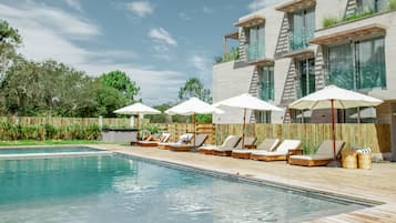 Piscine extérieure, parasols de plage, chaises longues