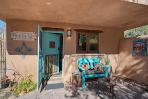 A turquoise door with a sign reading "DANCING HERE" and a bench with colorful cushions. - Dancing Hare - Colorful and Inviting Tesuque Home Right Next to Bishop`s Lodge (Santa Fe)
