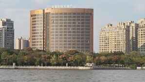 Un edificio de gran altura con un diseño arquitectónico moderno, que destaca por su fachada de vidrio y techo plano.