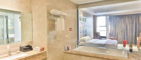 A modern bathroom with a large mirror, a bathtub, and a vanity with a sink.
