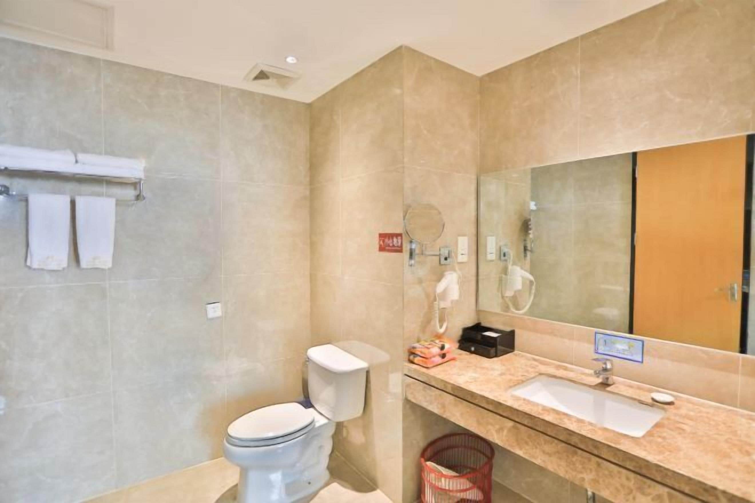 A modern bathroom with a toilet, sink, and mirror.