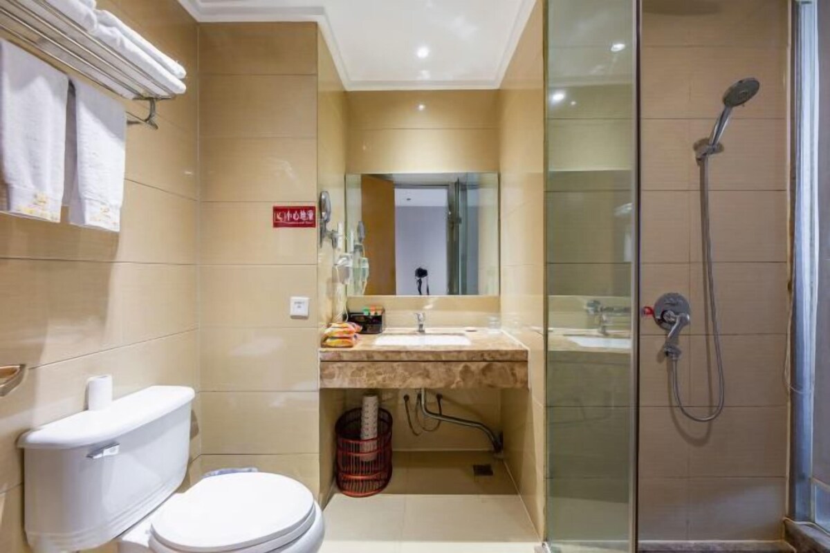Un baño con inodoro, lavamanos, espejo y ducha.