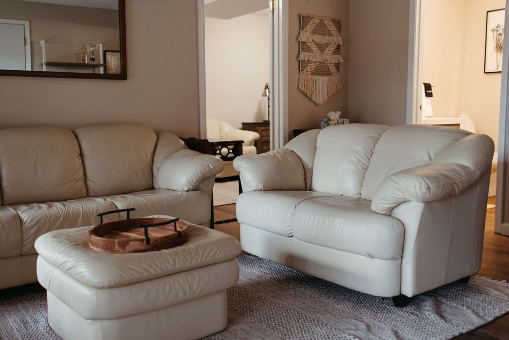 Una sala de estar con dos sofás color beige, una mesa de centro de madera y un tapete con textura.