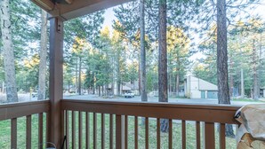 A wooden deck with a view of a forested area and a road. - Ultra Modern Mammoth Mtn 1 Bdrm WIFI, Spa, 2 cars (Mammoth Lakes)