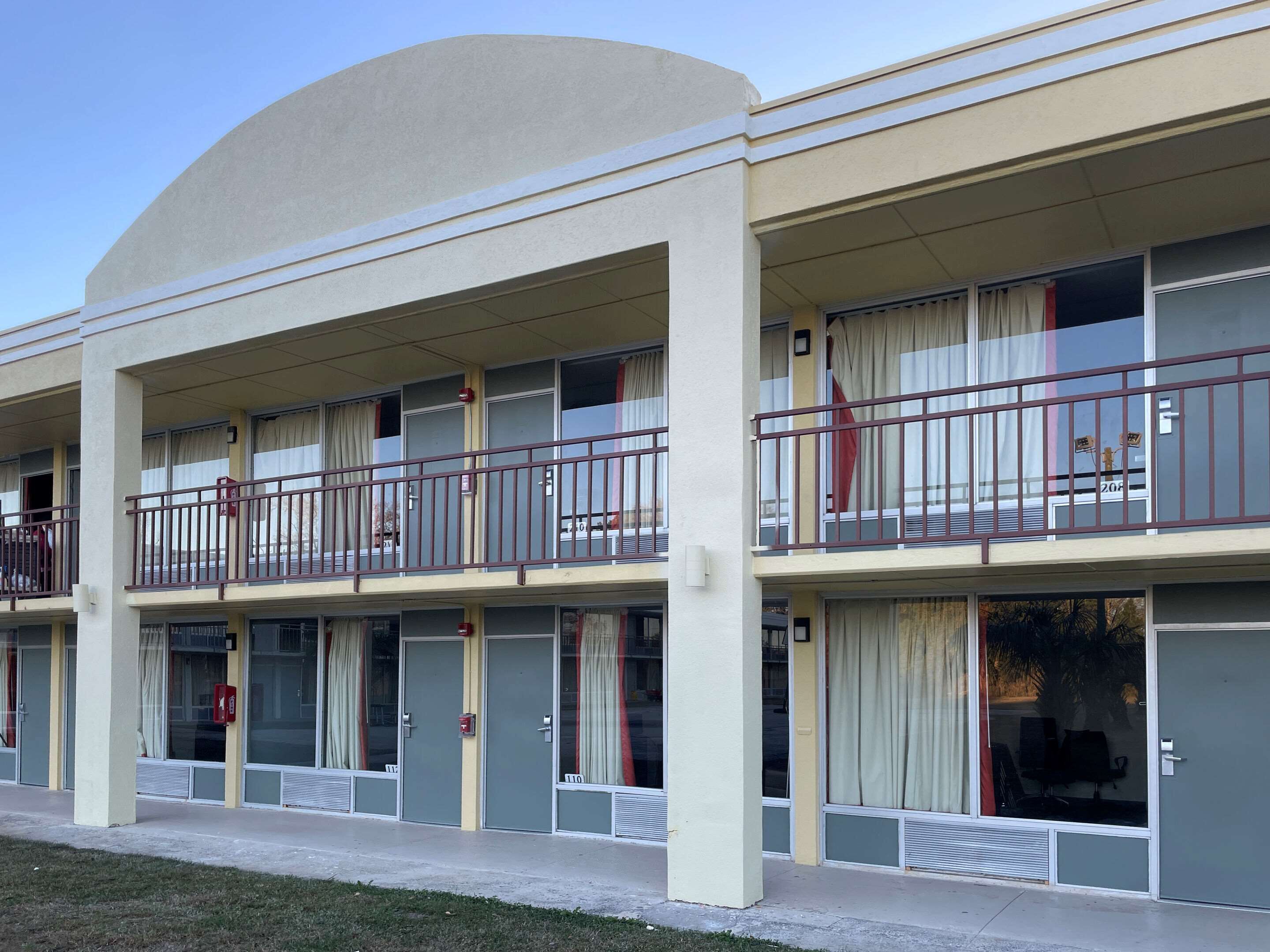 Un hotel de varios pisos con balcones, ventanas amplias y techo plano.