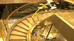 A spiral staircase with glass railings and a decorative light fixture. - Ruixiang Hotel (Fushun)