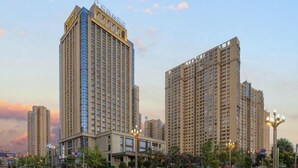 A high-rise hotel with multiple floors, a prominent entrance, and a well-lit plaza area. - Ruixiang Hotel (Fushun)