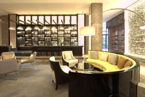 A modern bar area with a curved seating arrangement, a bar counter, and a well-lit interior. - Ruixiang Hotel (Fushun)