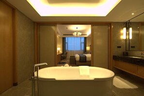 A modern hotel bathroom with a large bathtub, a separate shower area, and a vanity with a mirror. - Ruixiang Hotel (Fushun)