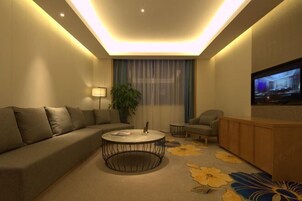 Una sala de estar moderna con un sofá, una mesa de centro, un televisor y una planta.