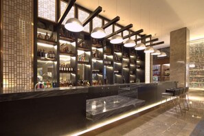A bar area with shelves of bottles, a marble counter, and hanging pendant lights. - Ruixiang Hotel (Fushun)