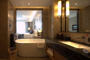 A modern bathroom with a freestanding bathtub, a large mirror, and a marble countertop. - Ruixiang Hotel (Fushun)