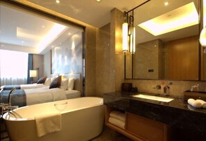 A modern hotel bathroom with a large bathtub, a vanity with a mirror, and a separate shower area. - Ruixiang Hotel (Fushun)