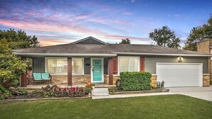 A single-story house with a front porch, a garage, and a well-maintained lawn.