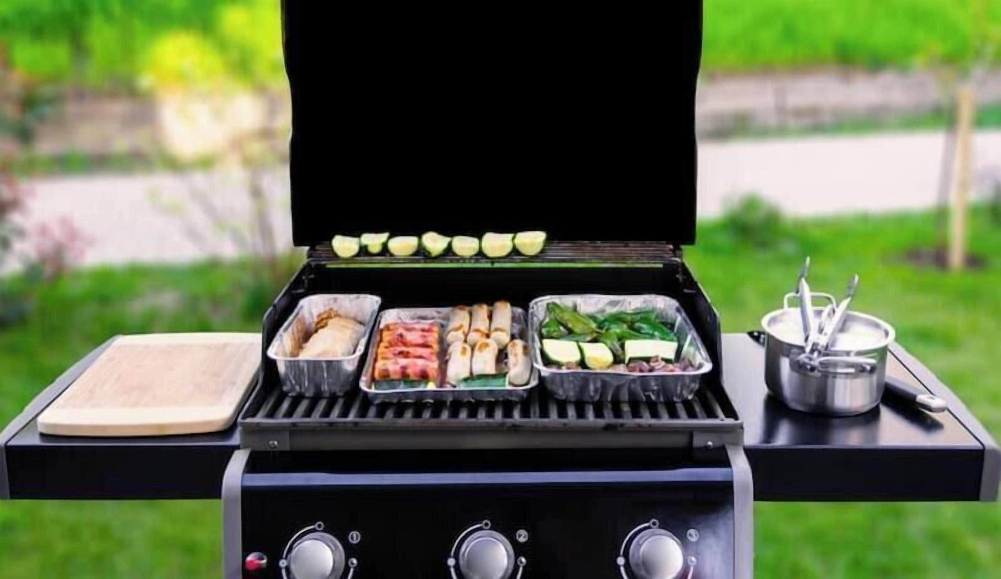 A barbecue grill with various meats and vegetables.