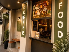 Ett kafé med en menytavla, en skylt med kaffe och en skylt med mat.
