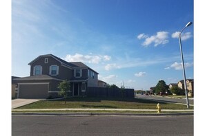 Stunning two-story home with a garage and front yard, offering a serene outdoor space.
