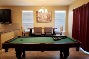 Enjoy a game of pool in our spacious room with a pool table, comfortable seating, and a large window.