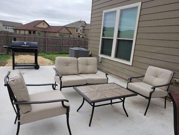 Relax on the patio with a sofa, armchairs, and a small table.