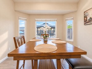 A dining area with a wooden table, woven placemats, and chairs. - Beautiful home W/Pool Close to National Parks. (Fresno)