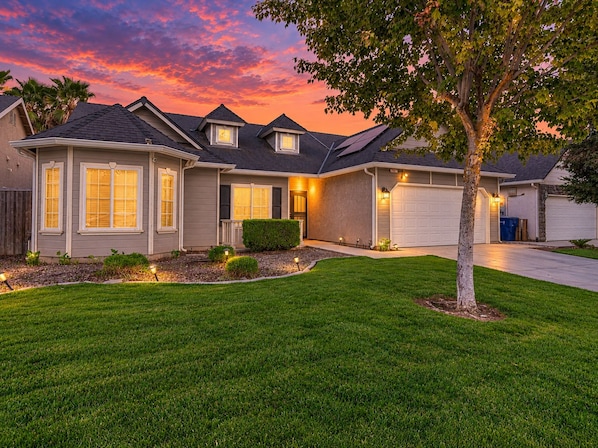 A residential house with a well-maintained lawn, a driveway, and a garage. - Beautiful home W/Pool Close to National Parks. (Fresno)