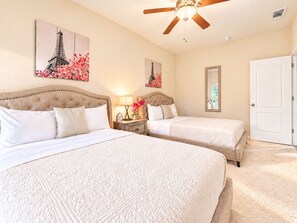 A hotel room with two beds, a ceiling fan, and artwork on the walls. - Beautiful home W/Pool Close to National Parks. (Fresno)