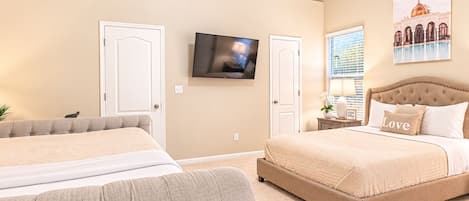 A hotel room with two beds, a television, a window with blinds, and a painting on the wall.