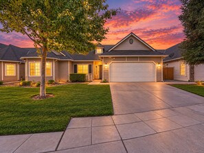 A residential house with a driveway, garage, and well-maintained lawn.
