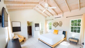 Un dormitorio con cama, mesita de noche y ventilador de techo.